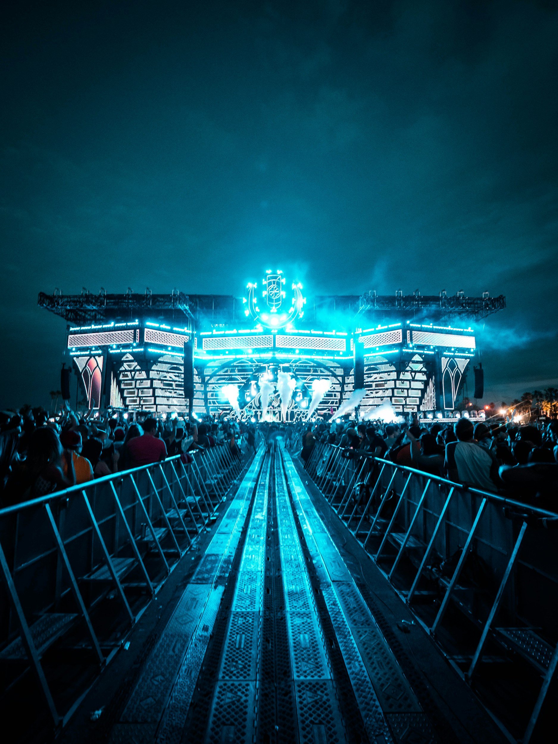 An outdoor music festival stage illuminated in blue at night