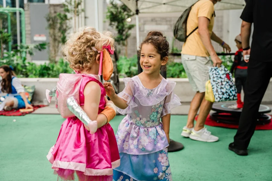 Two children in pink and lavender princess dresses