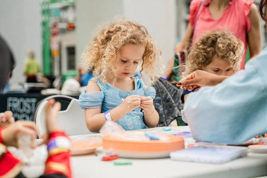 A child in a blue costume enjoying a craft activity